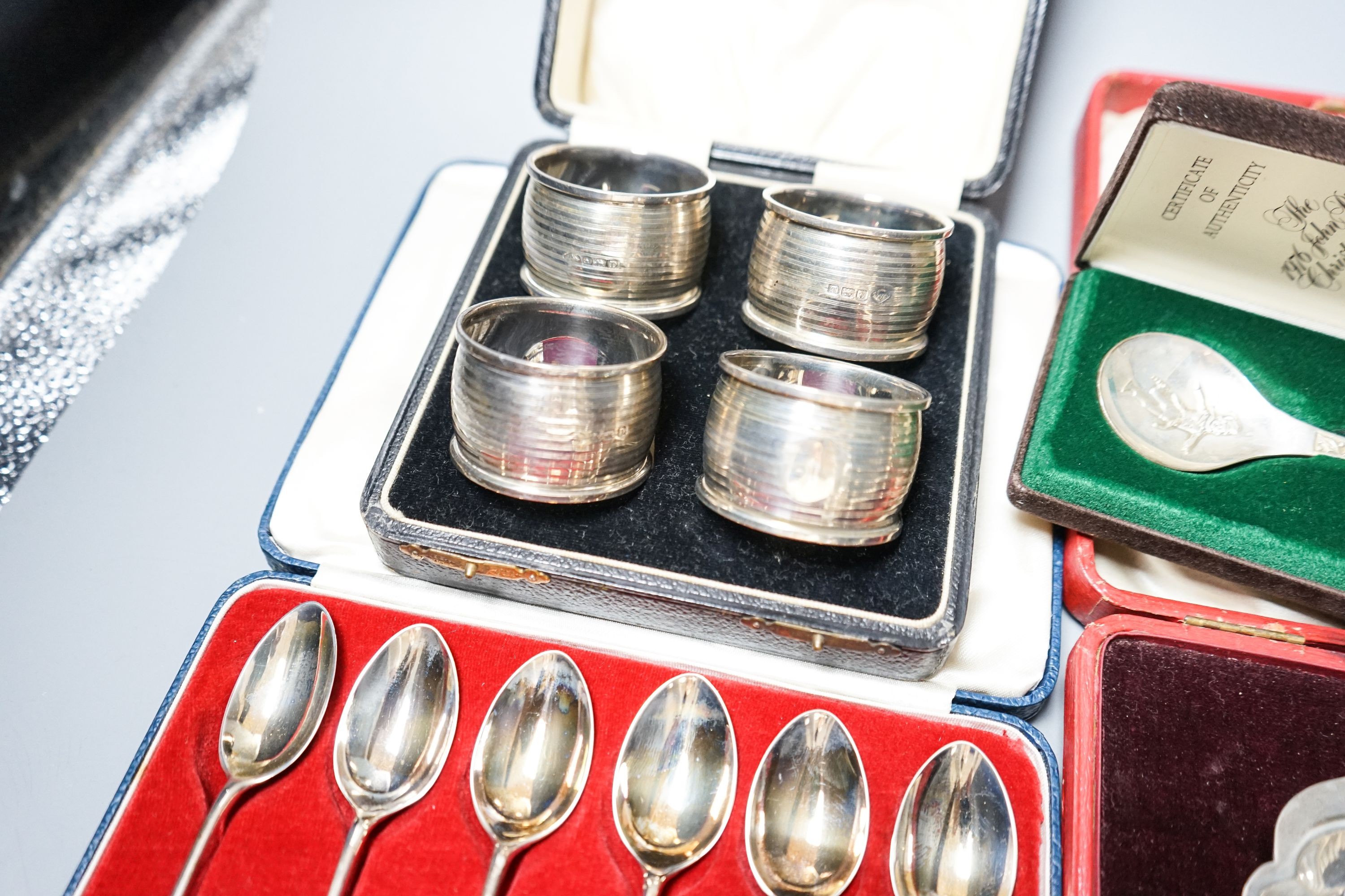 A cased pair of four 1920's silver napkin rings, four other cased items including butter shell and a pair of silver mounted dwarf candlesticks.